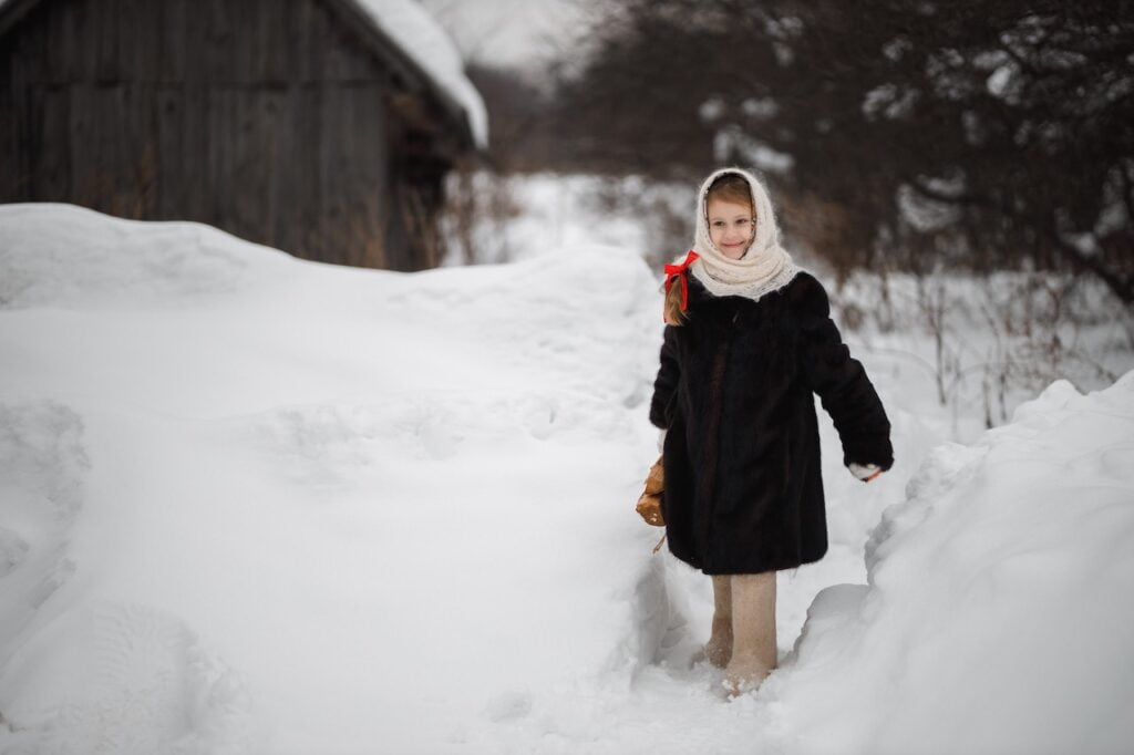 Girl outdoors building a snow mound